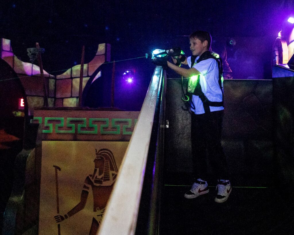 kid shooting a laser gun from a ledge