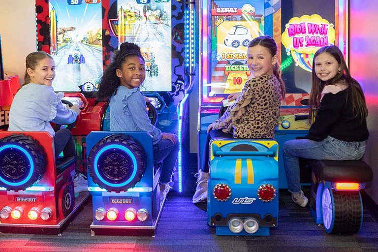 kids sitting on arcade machines